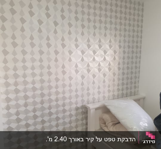 קיר מודבק בטפט בדוגמה גיאומטרית בחדר שינה